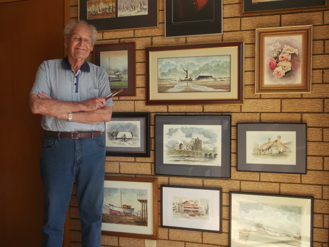 Peter Robinson standing in front of artworks