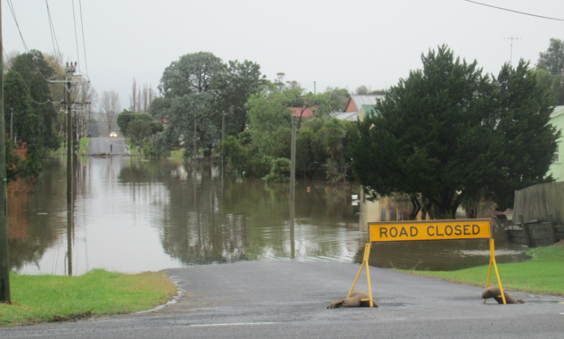 Warning sign at flooded street in Bega