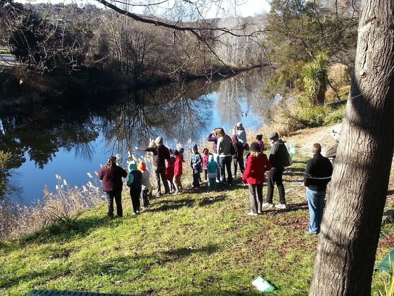 Group of people standing on the bank of Queanbeyan River