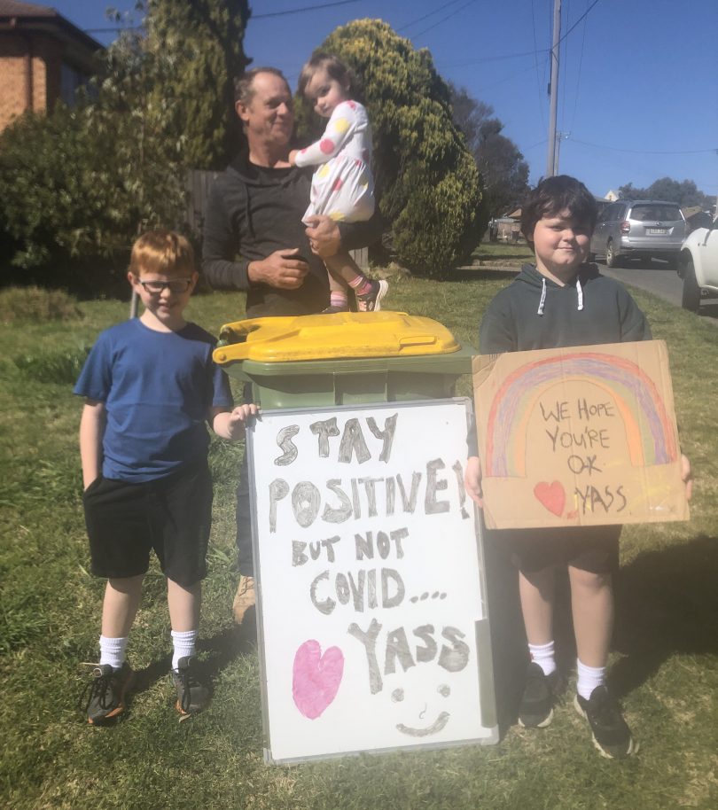 Max, Quinn, Paul and Frances outside their home in Yass, holding signs