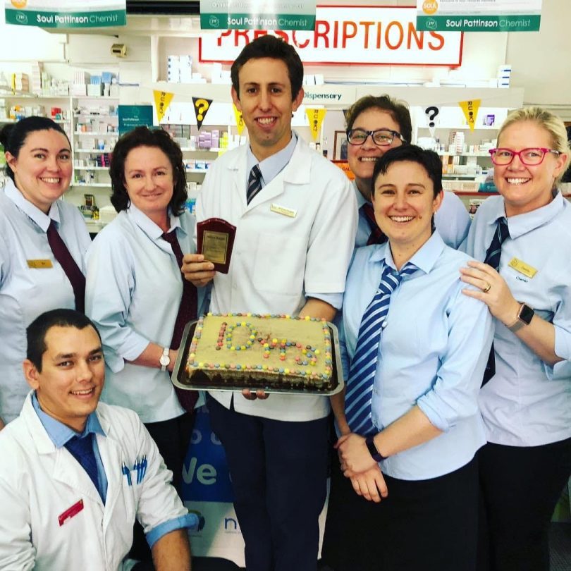 Andrew Douglas holding cake with Priceline Pharmacy Yass staff