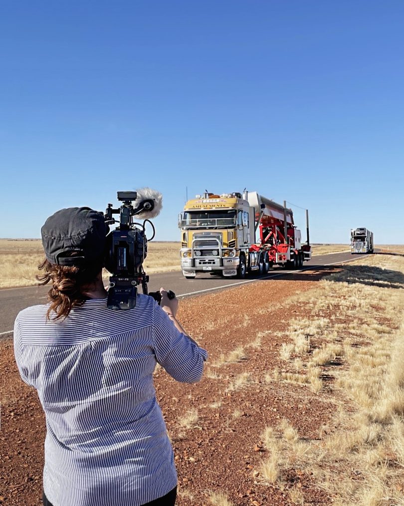 Isabel Darling filming trucks on highway for 'The Carnival'