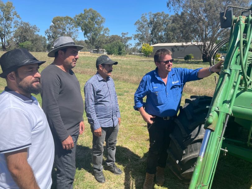 TAFE NSW agriculture teacher Andrew Baxter shows the Yazidi students some of the components of a tractor as part of a unique TAFE NSW course. Pictured are (from left) Shahab Mahmood from Red Cross Australia, and students Khadida Hasan and Khalaf Smoqi.