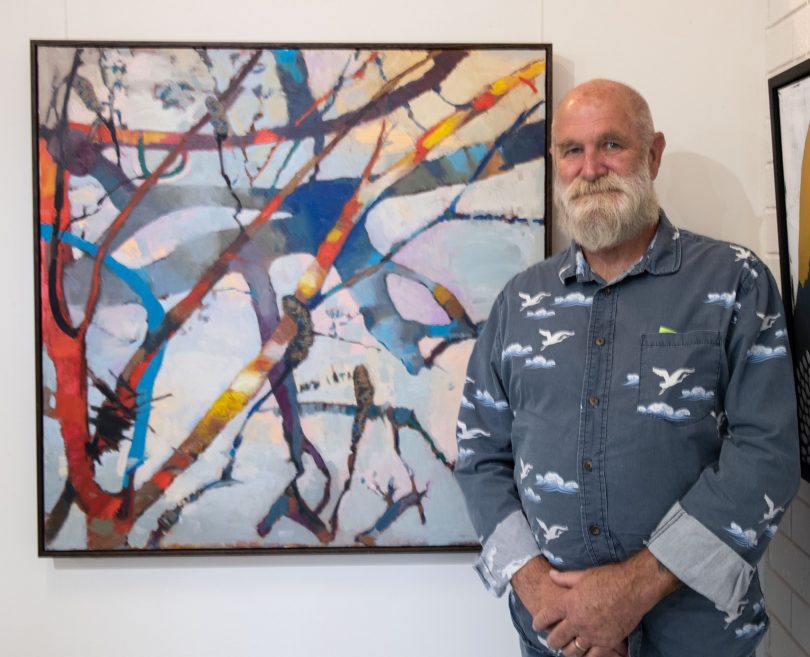 Geoffrey Odgers standing beside his artwork