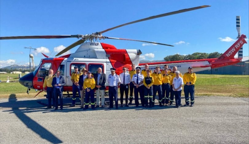 David Elliott, RFS members and Rob Rogers standing in front of a helicopter