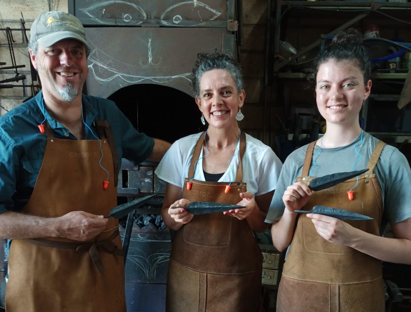 Dave Newell, Debra Summer and Ruby Newell hold leaves forged from steel for the Cobargo Community Tree Project