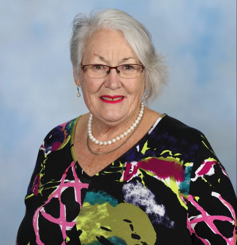 A portrait-type photograph of a smiling older woman with grey hair