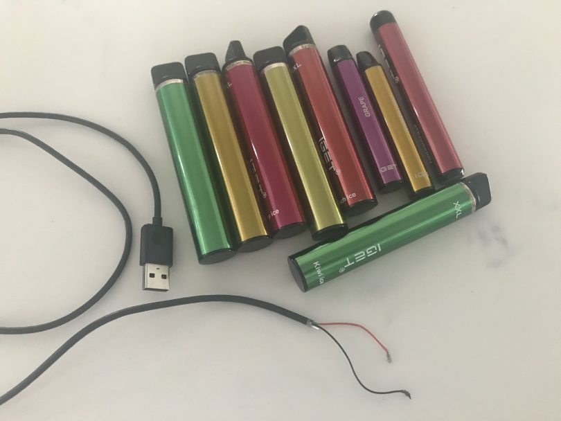 A selection of vapes and cut USB charger