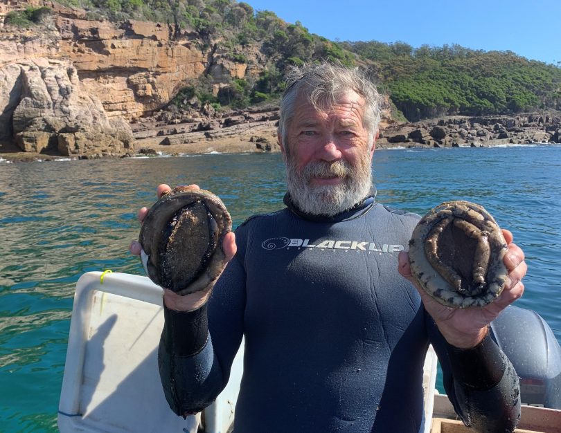Diver holding two abalone