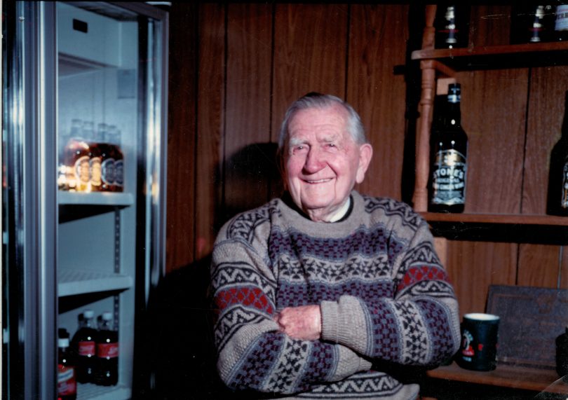 Man with arms folded behind the bar