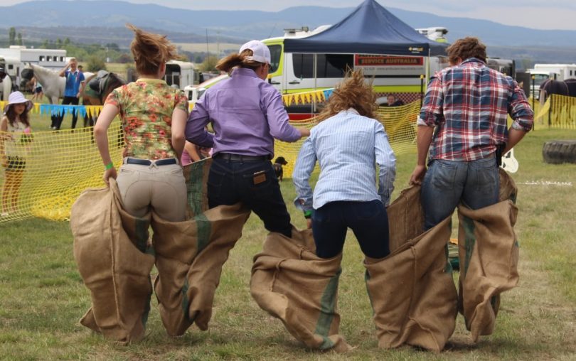 four people in a country fair sack race