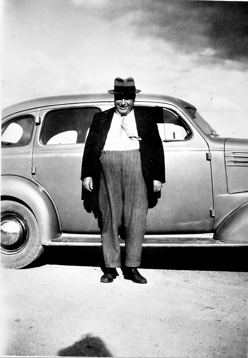 black and white photo of man in front of car
