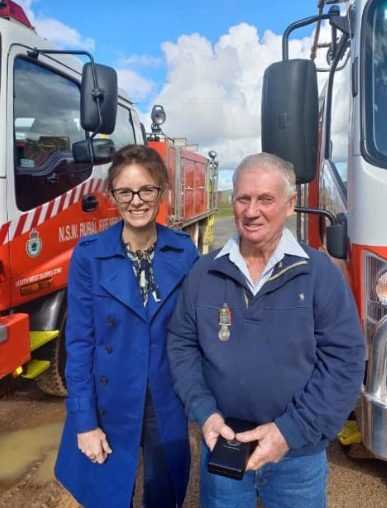 NSW Minister for Emergency Services and Resilience and Minister for Flood Recovery Steph Cooke with fire fighter in front of fire trucks