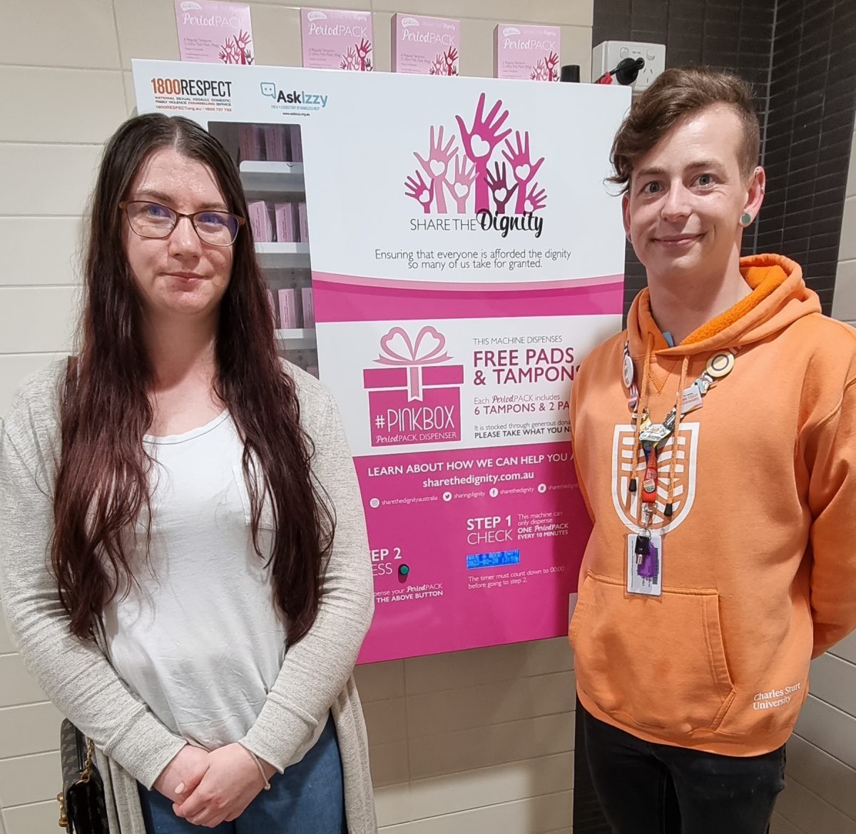 third-year veterinary technology student Ricki-Sue King and Charles Sturt University equity, diversity and inclusion advisor Nicholas Steepe in front of Share the Dignity vending machine