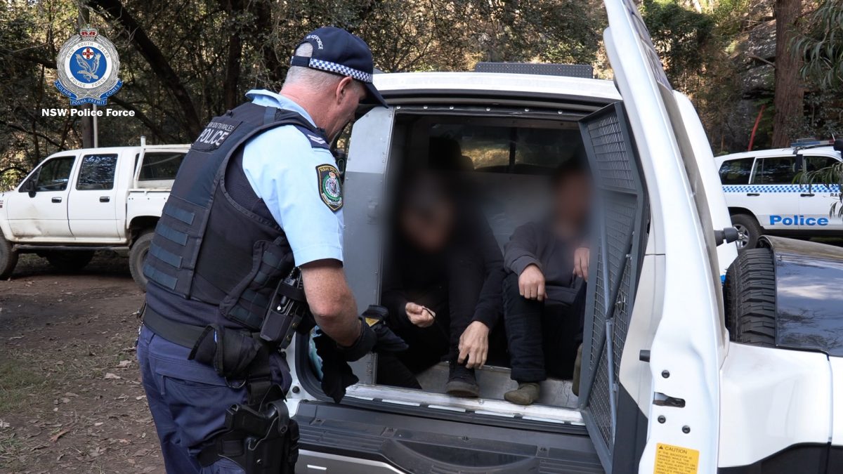 People in the back of a paddy wagon and a police officer