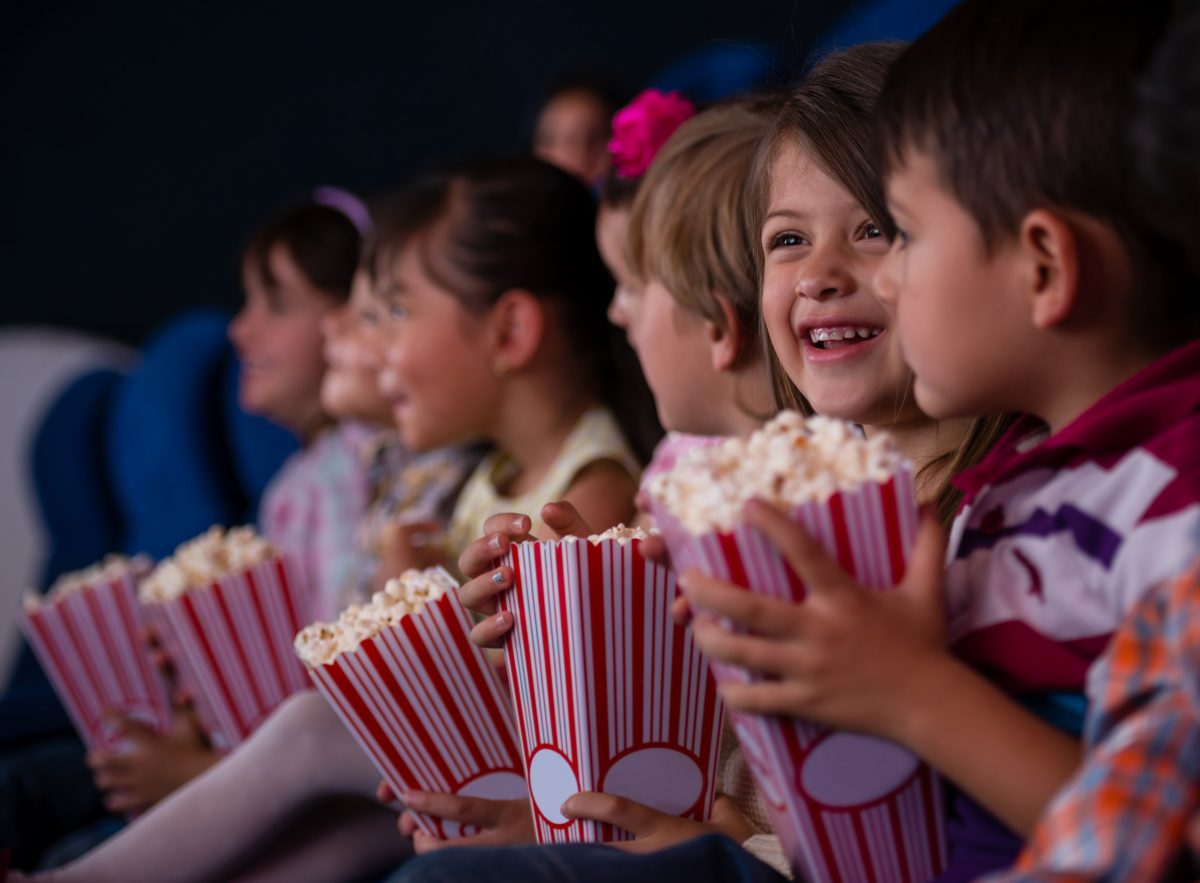 Kids holding popcorn at a cinema