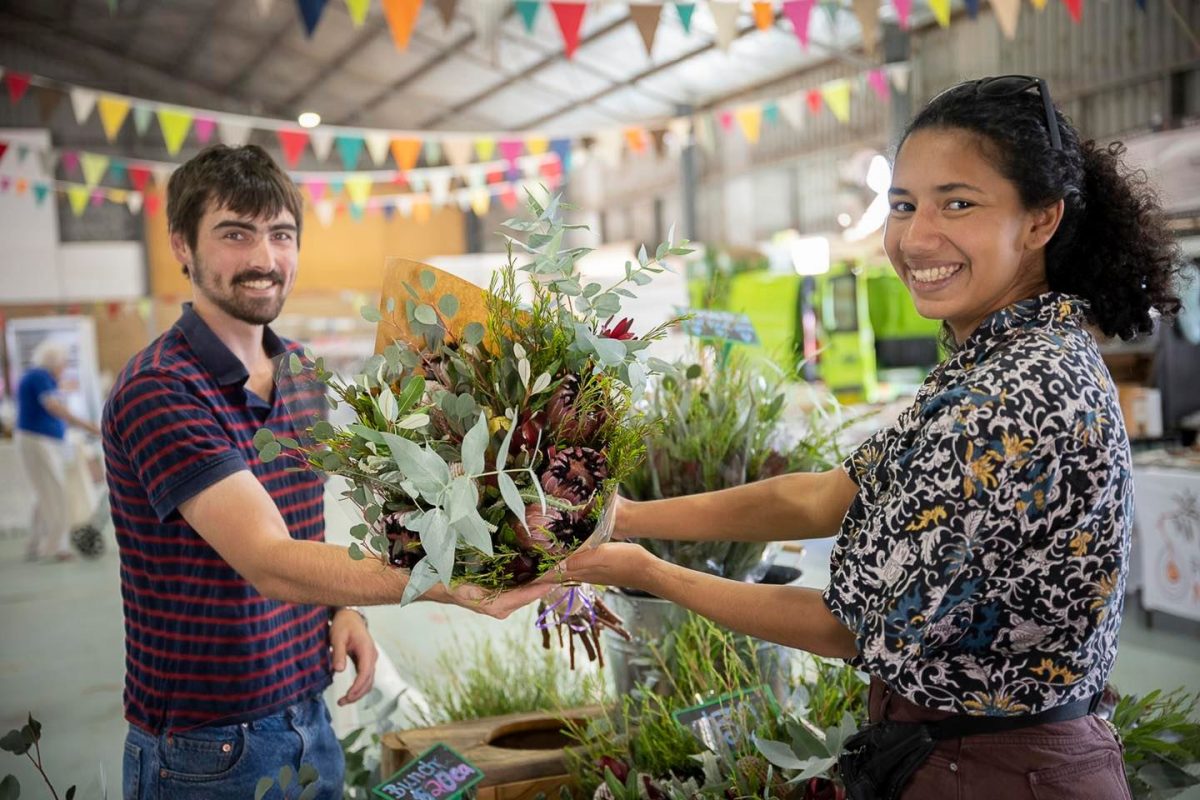 People holding fresh flowers at the Riverina producers market