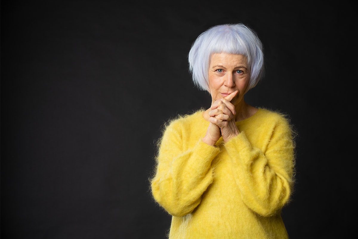 Woman with white hair in a yellow jumper