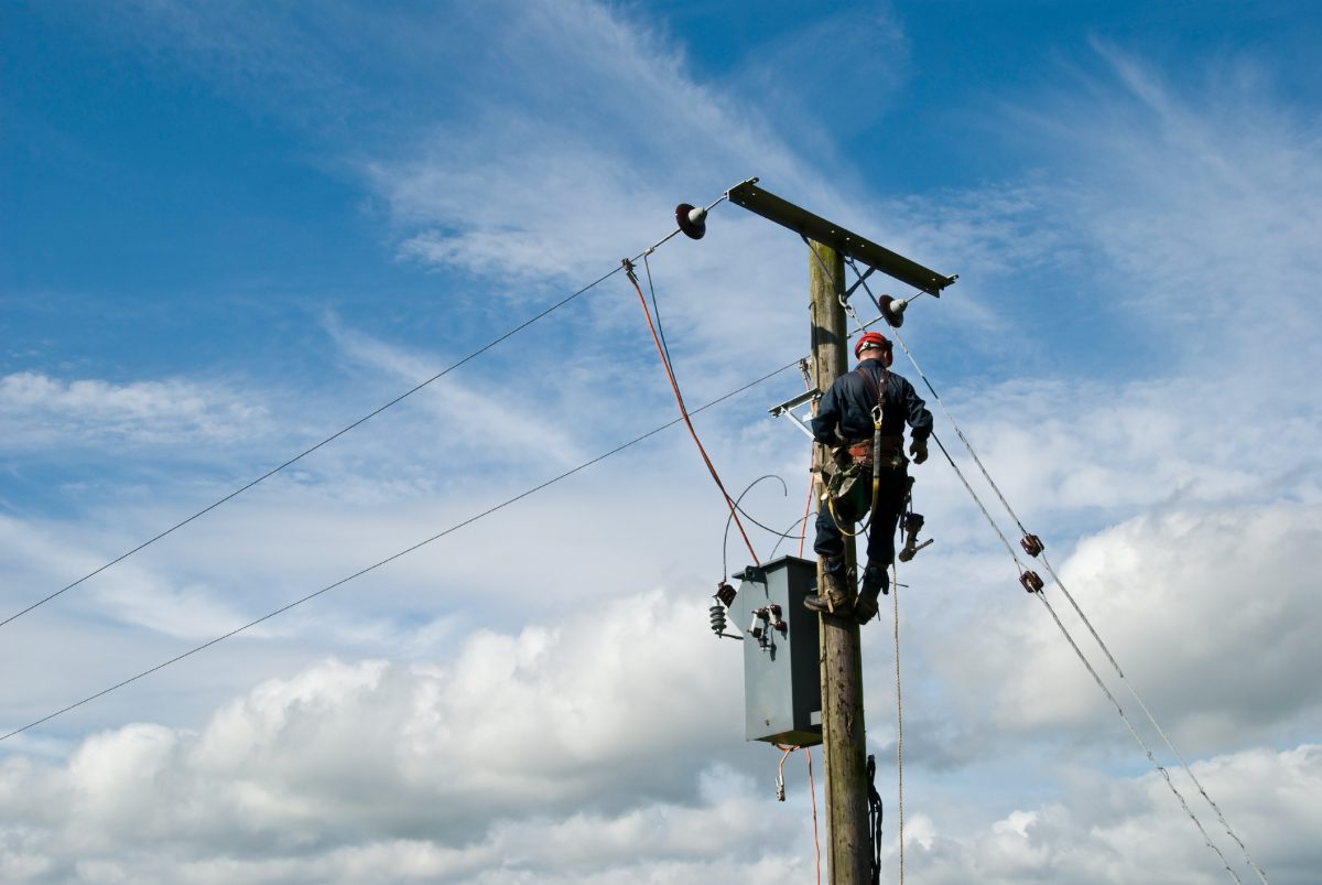 worker climbs power pole