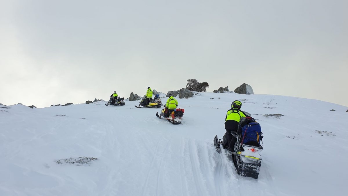 rescue crews on snowmobiles