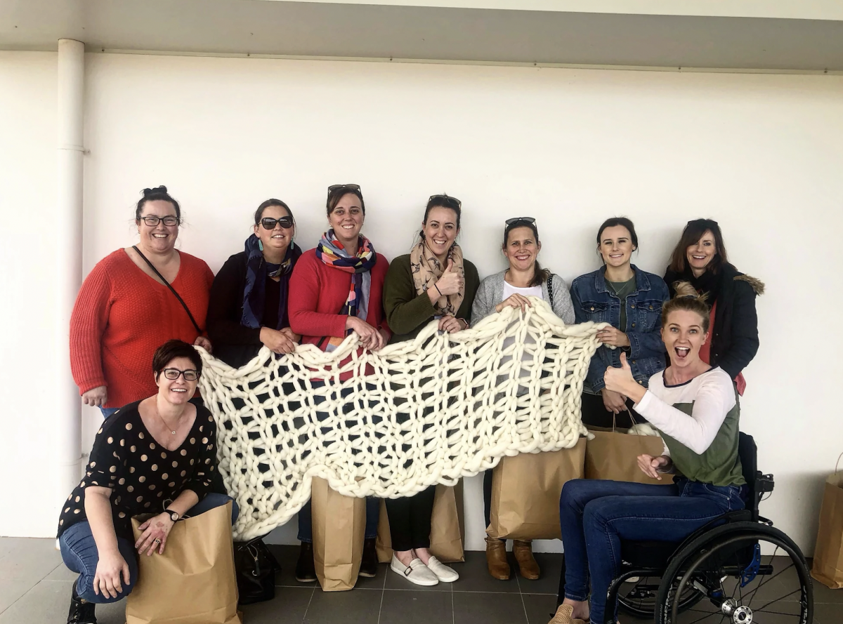 Women holding a hand-woven throw