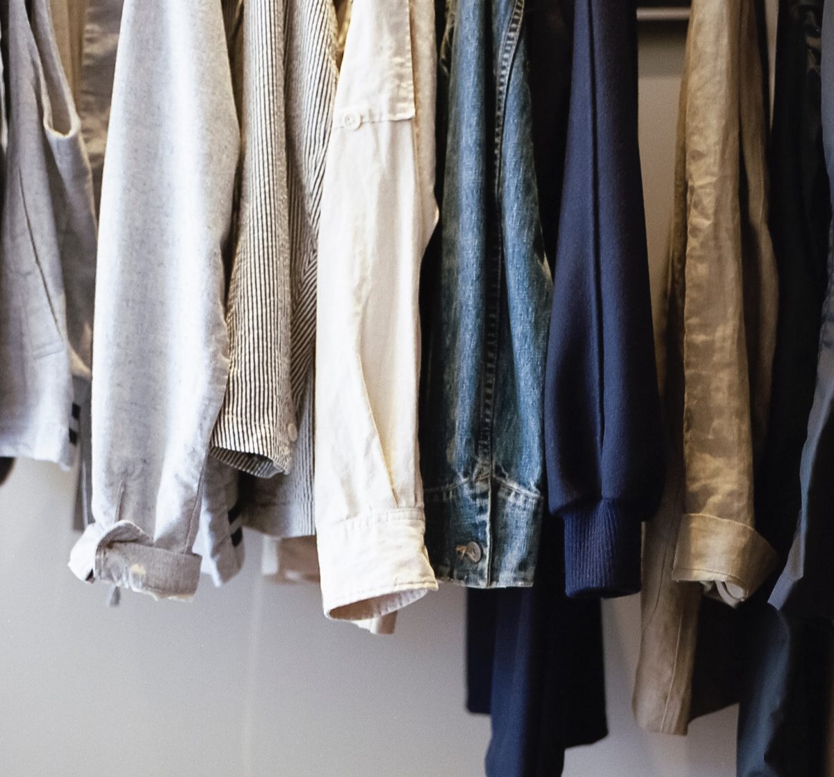 close up of sleeves of shirts hanging on a rack