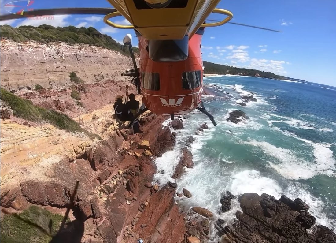 Helicopter winching person to safety