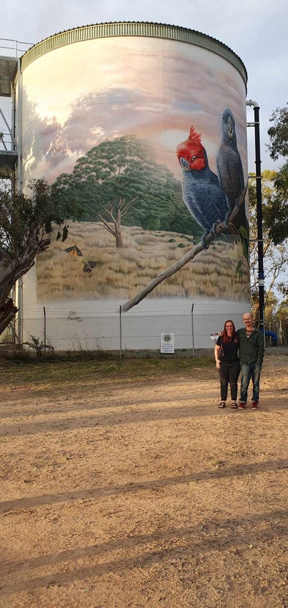 Man and woman in front of mural 