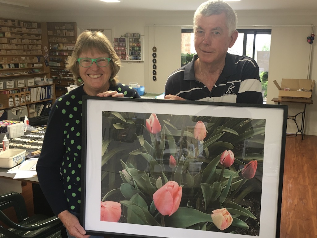 A couple with a framed image of tulips