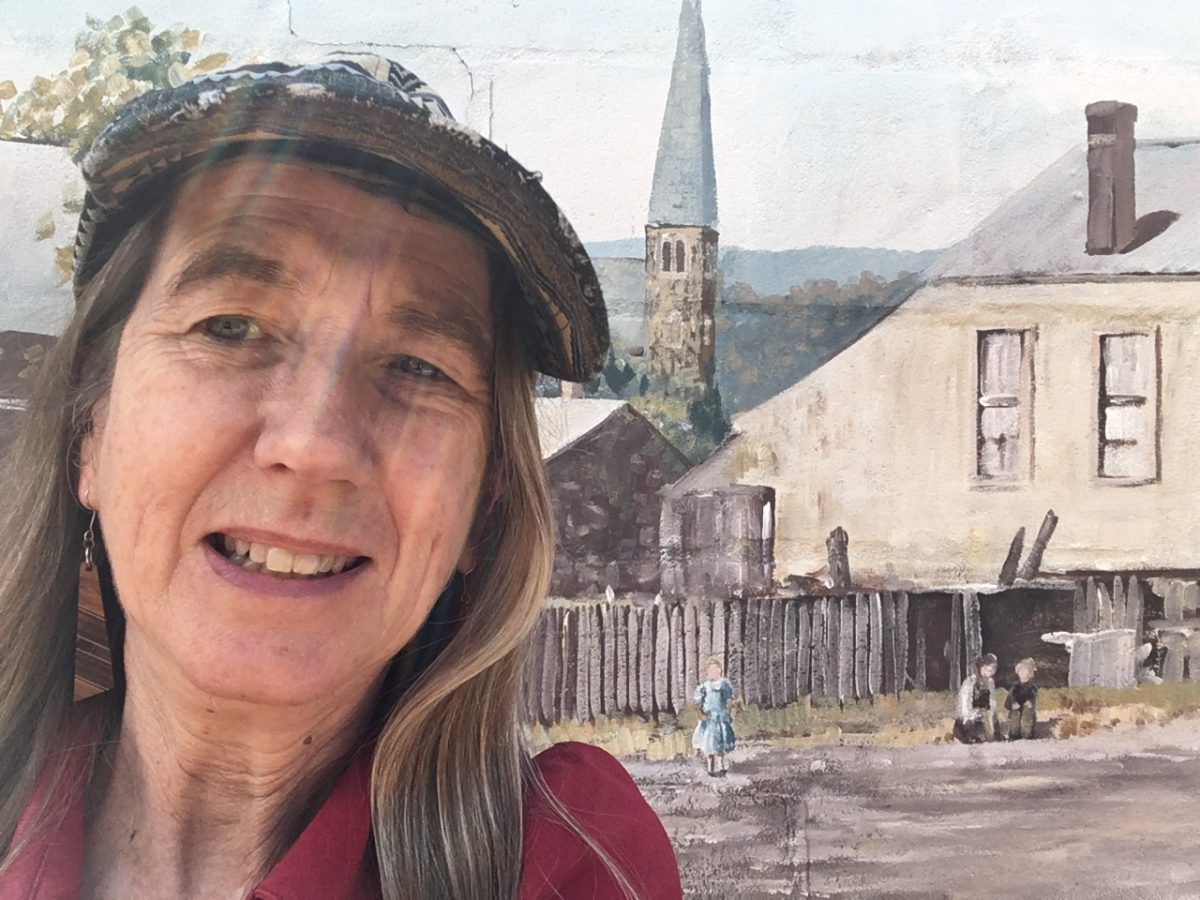 Woman in front of wall mural