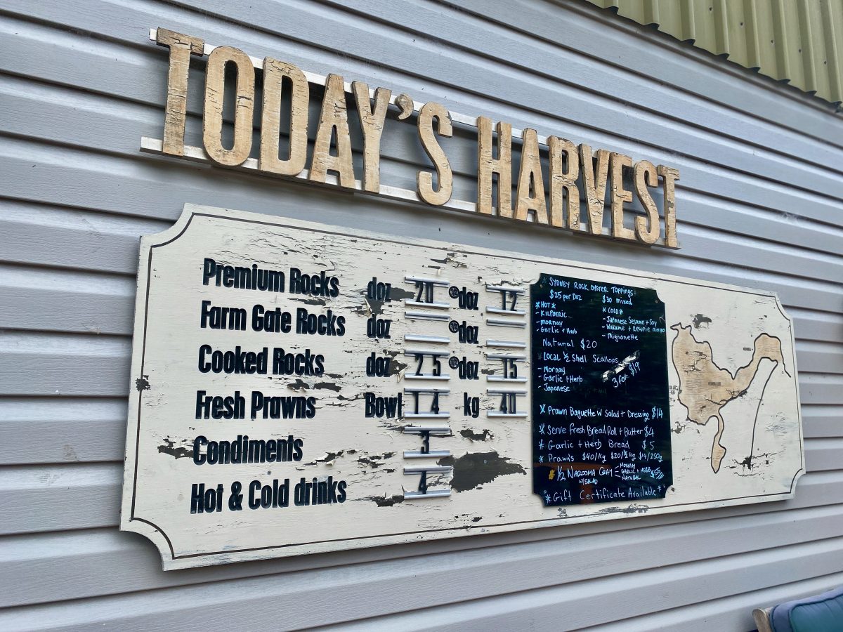 A sign reading "Today's Harvest" with a list of prices for oysters and prawns, and a menu of various toppings.