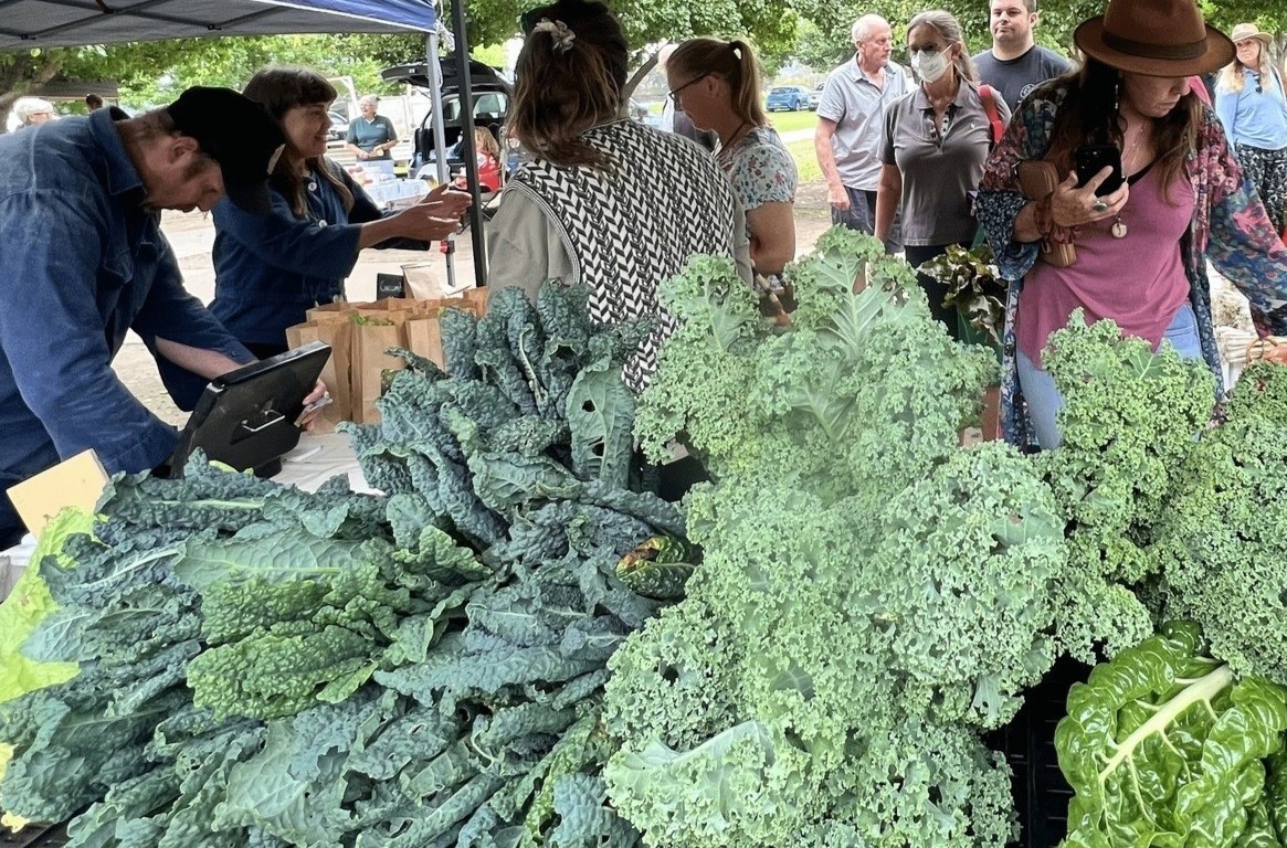 Customers queue up for vegetables at SAGE Farmers Market.