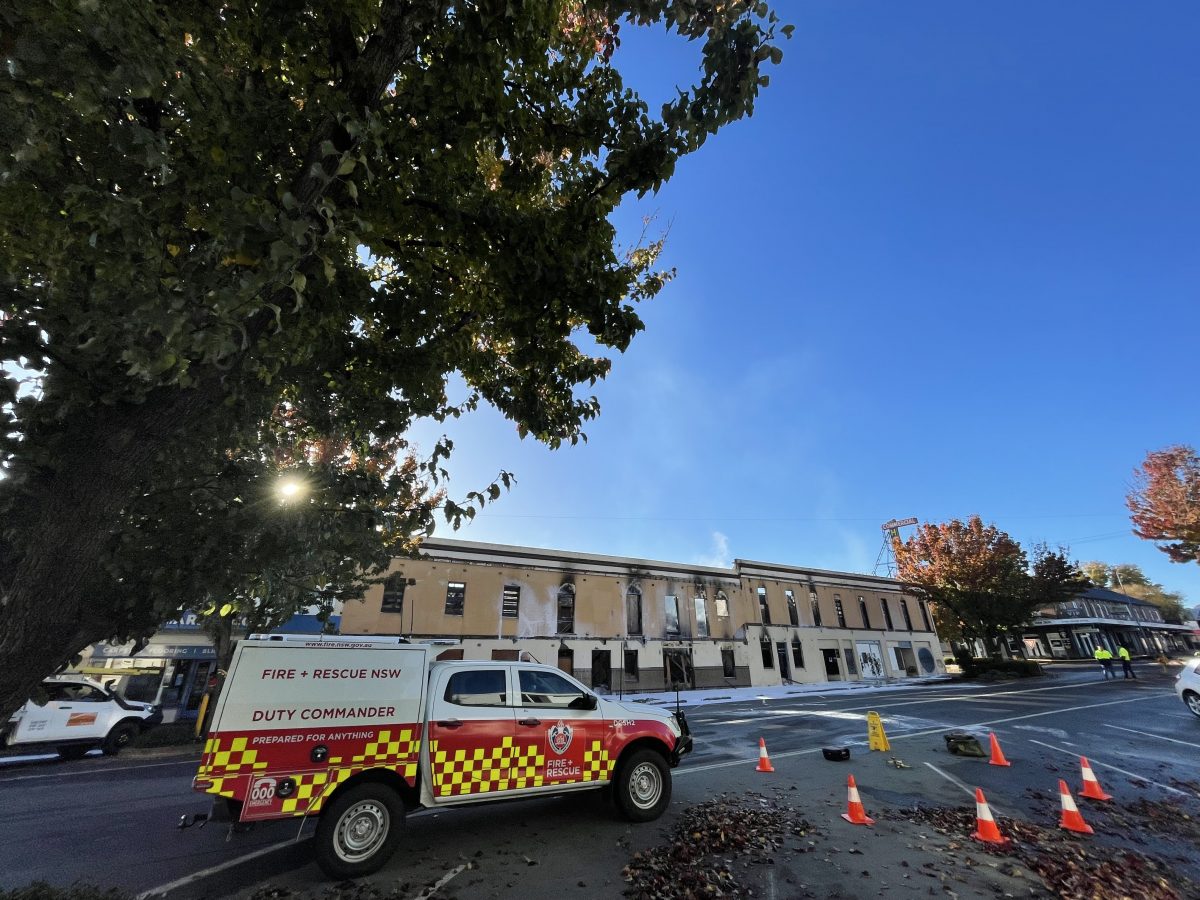 The damaged Commercial Hotel with a Fire and Rescue NSW truck, with blue sky above