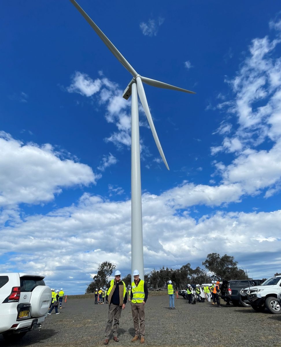 people standing around a wind turbine
