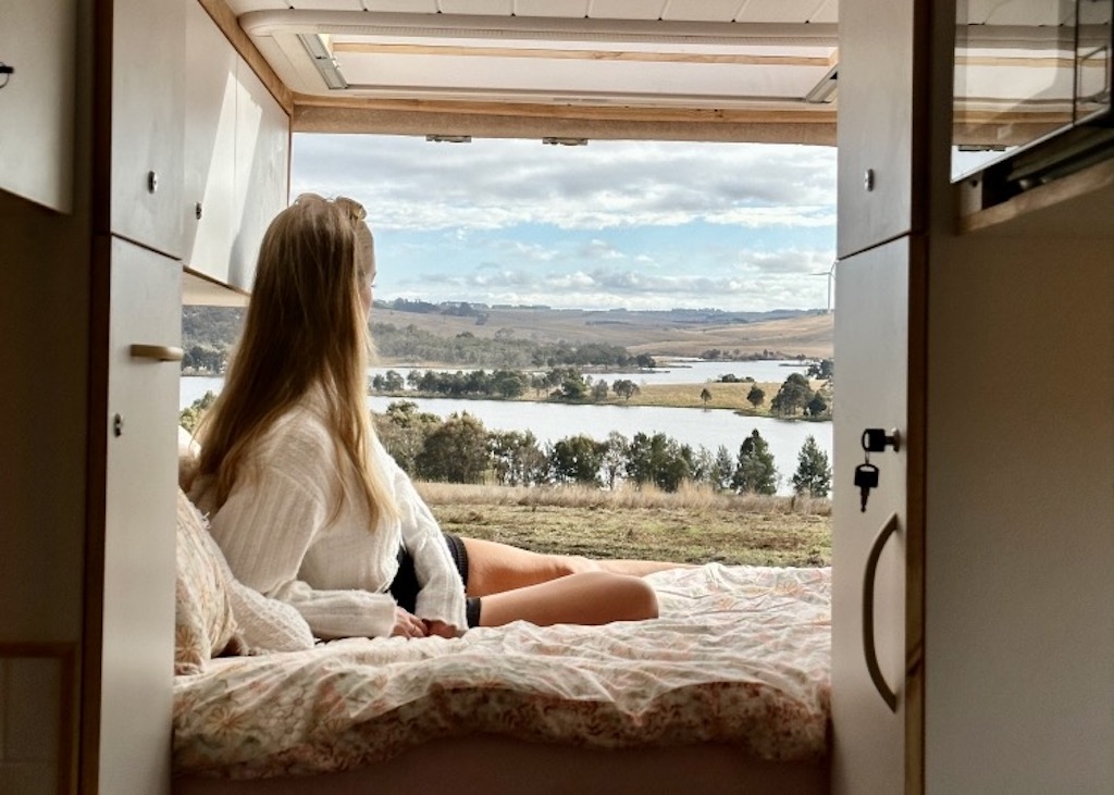 woman admiring dam view from bed