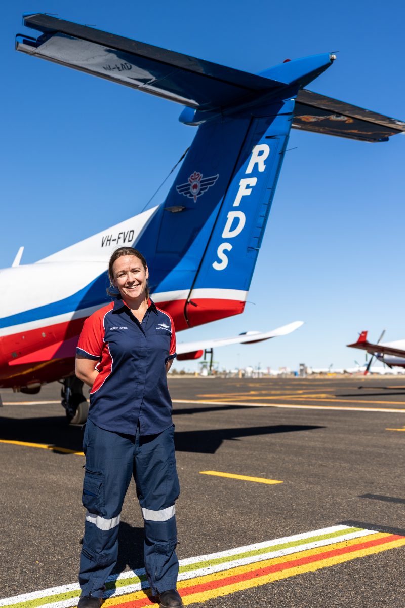 Woman in front of Flying Doctor Service plane