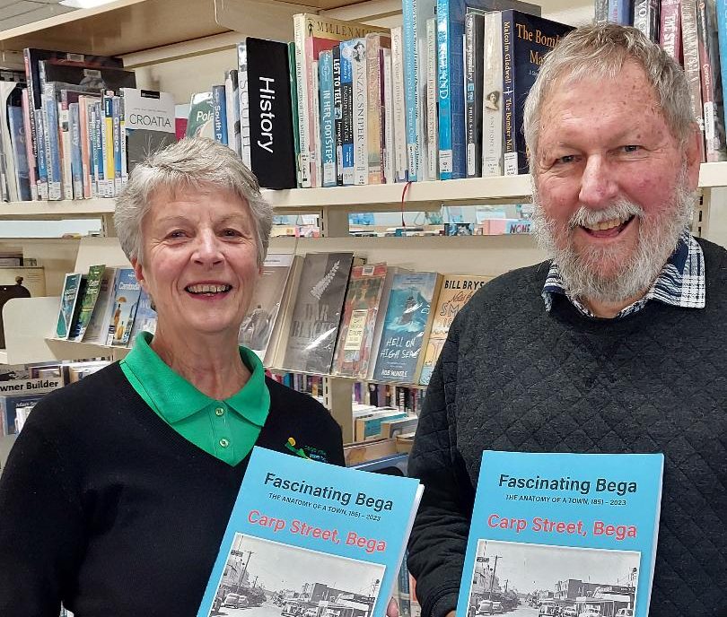 South Coast History Society president Peter Lacey delivers copies of Carp Street, Bega to Anne, a librarian at Bega Library