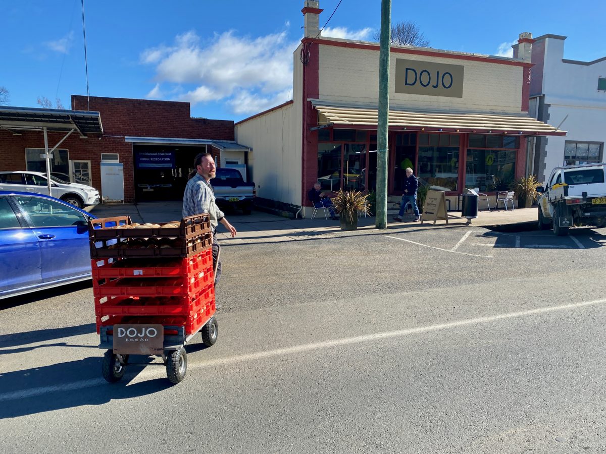 Man crossing road with bread trolley