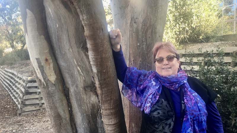 Woman leaning on tree