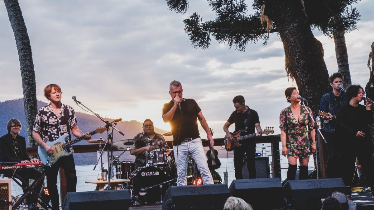 rock band performing on stage in tropical setting