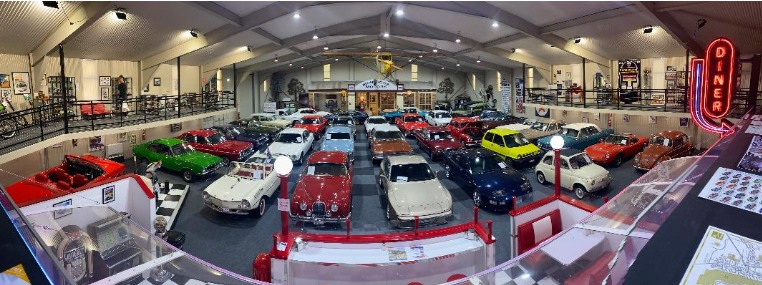 A panorama of a lot of cars, parked indoors