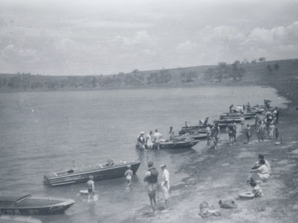 Historic photo of boats on lake shore.