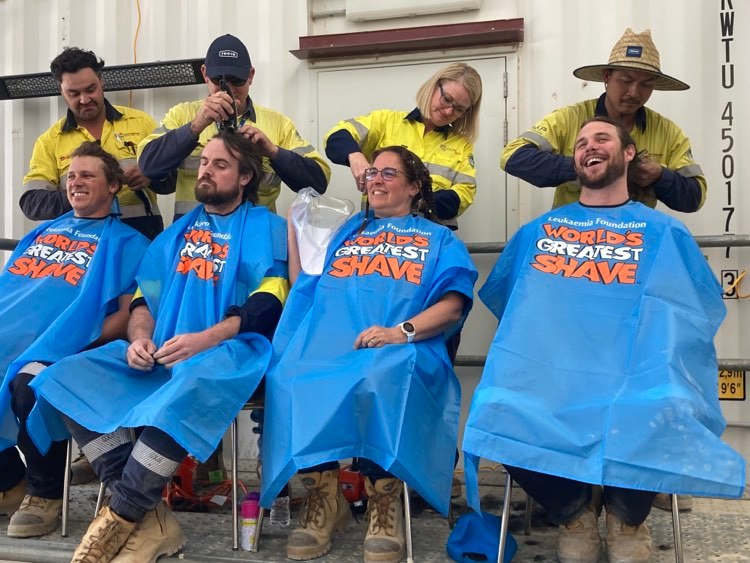 four people having their hair shaved