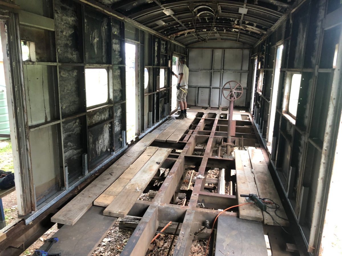 man in train guards' carriage under restoration