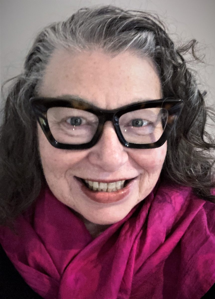 A woman in glasses looking at the camera in a selfie