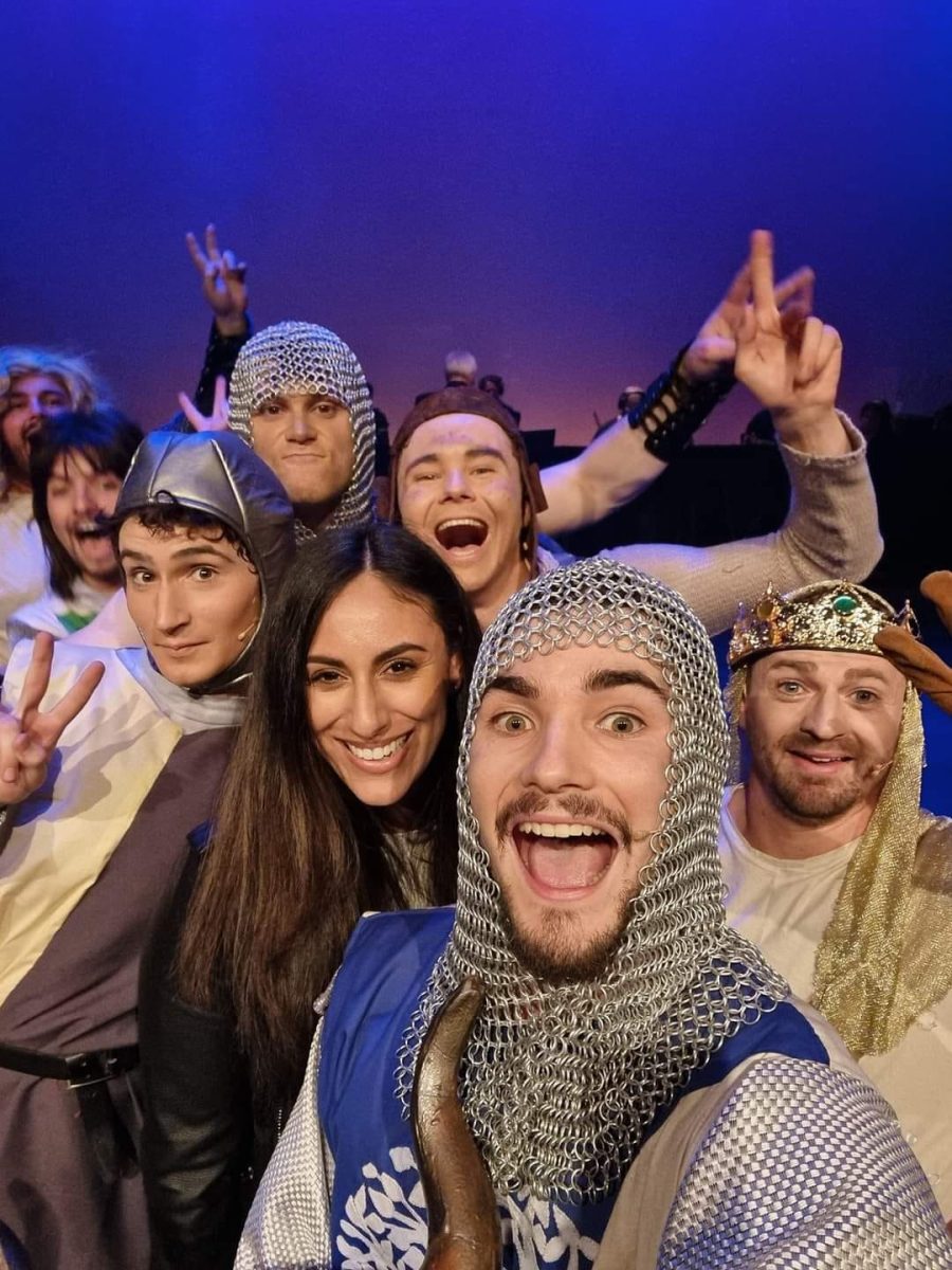 A vertical selfie of a group of actors in medieval costumes