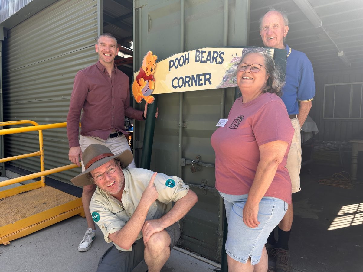 Four people standing around the updated sign