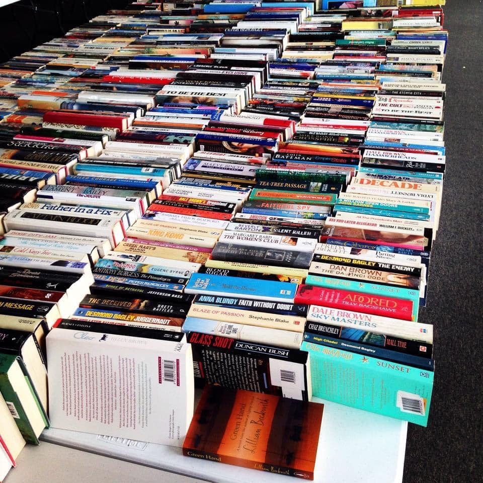 A table with rows of books, spines up