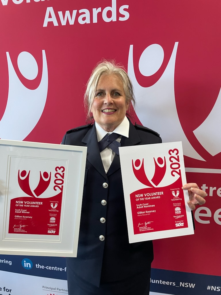 A woman holding certificates, one framed