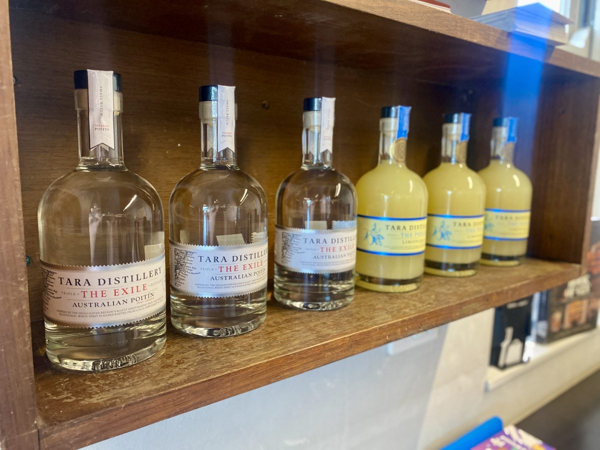 Bottles of clear Poitin and yellow limoncello on a shelf